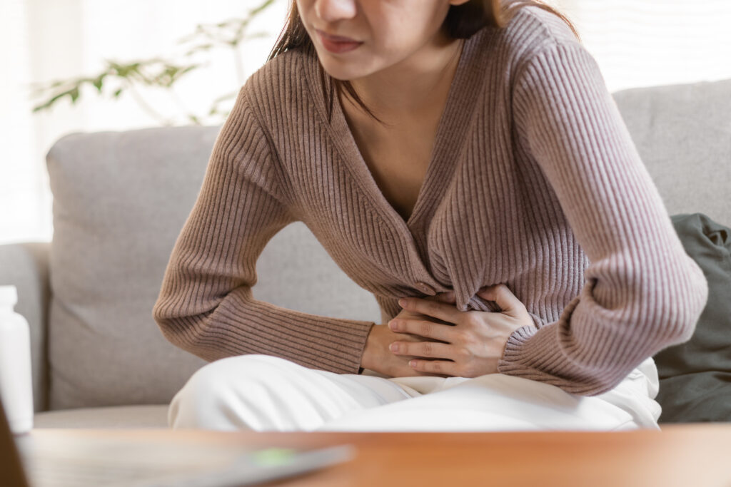 Young woman holding her pelvic area in pain needing care in Los Angeles, CA